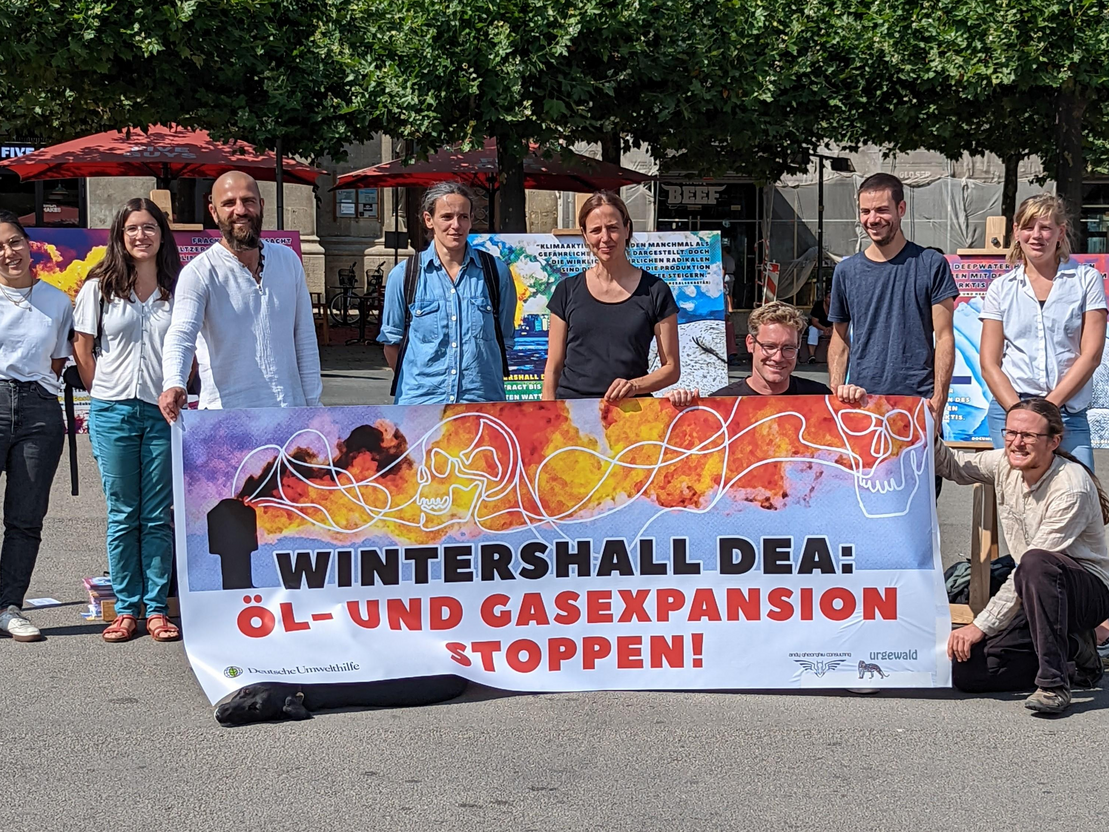 Menschen stehen mit einem Plakat zusammen